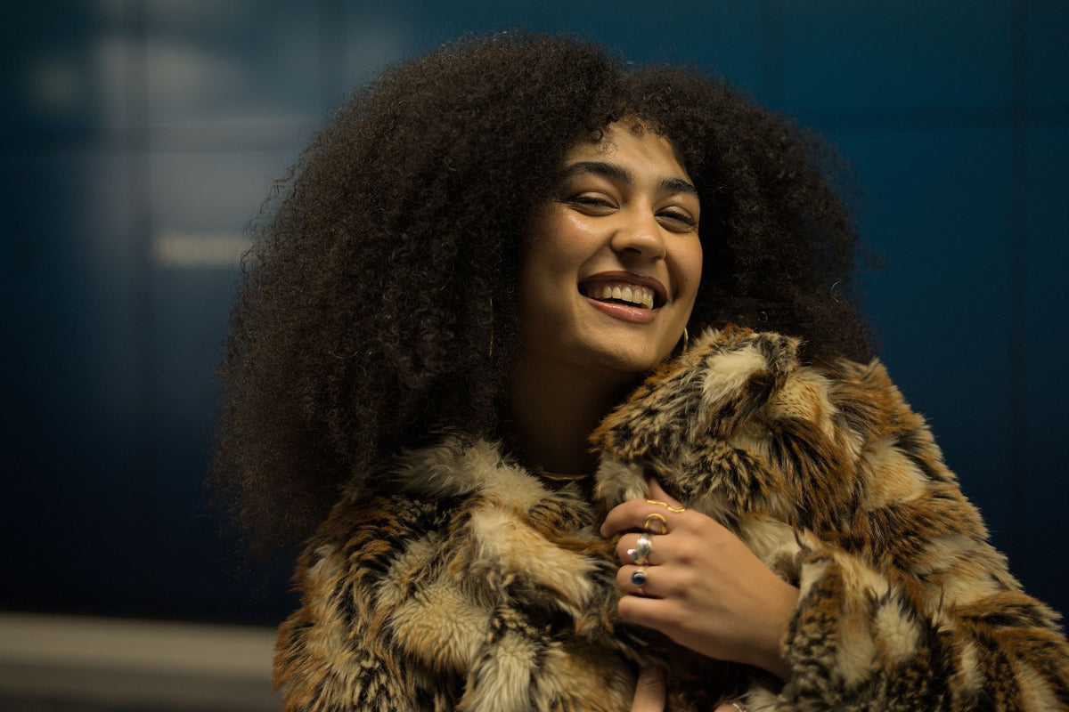 Femme aux cheveux frisés protégés du froid et de la sécheresse hivernale