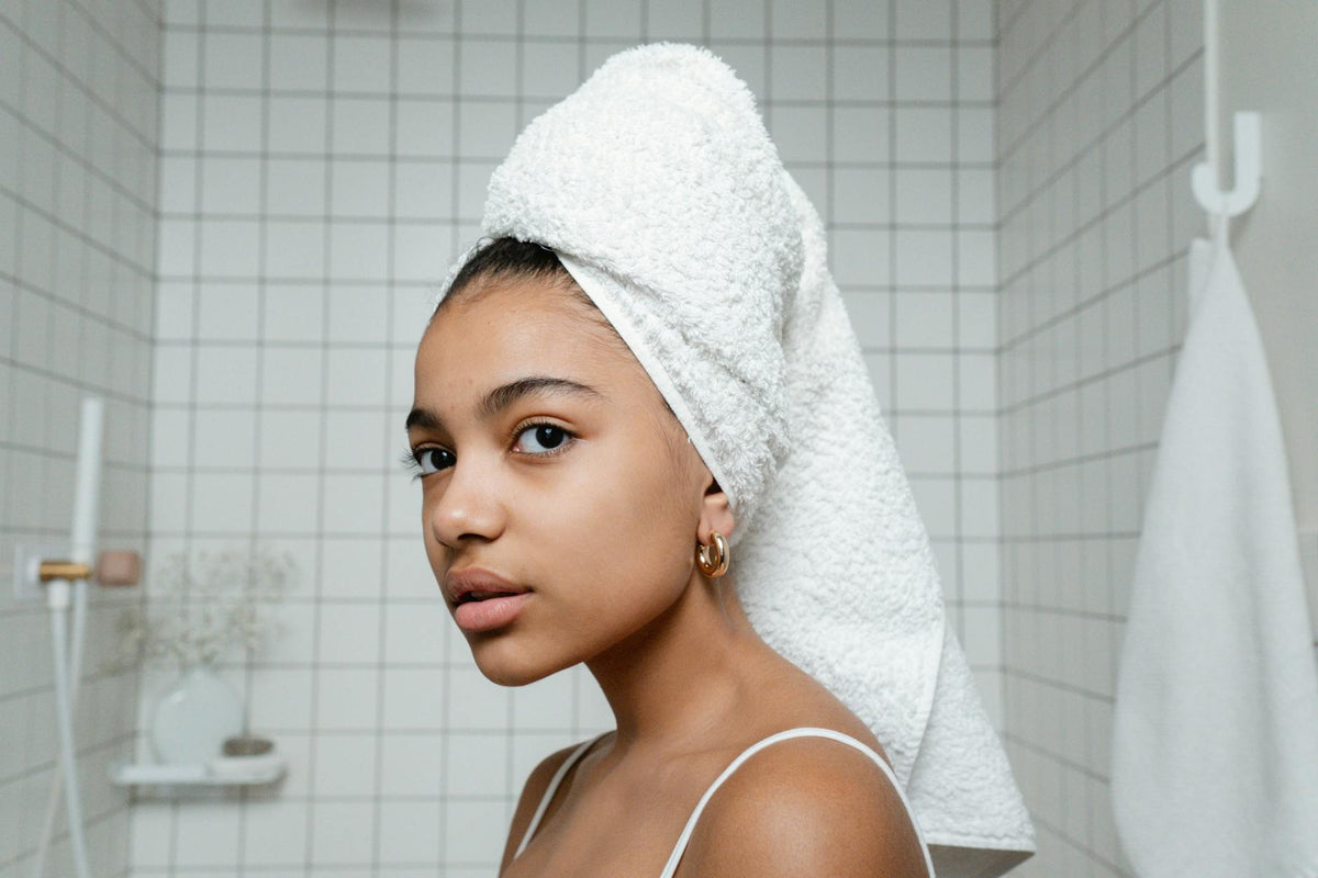 Femme avec serviette cheveux après la douche - routine soin capillaire quotidienne